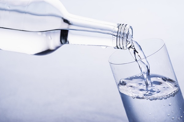 Pouring clear water in glass. Water glass bottle